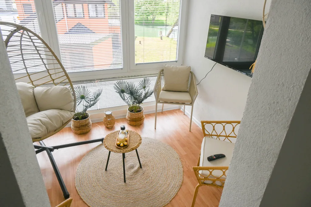 Dnevni boravak apartmana sa velikim prozorom i pogledom napolje.